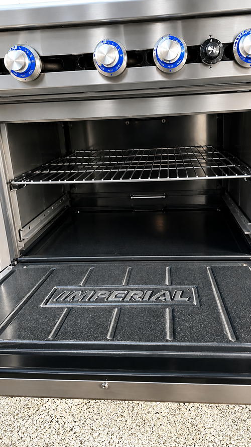 Close-up of the cast iron burners on the Commercial Natural Gas Imperial Six Burner Range Oven, highlighting its efficient two-ring flame system.